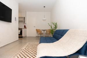 a living room with a blue couch and a kitchen at Casa Korsi Apartments At Santa Ana in Panama City