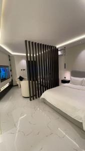 a bedroom with a large white bed and a television at Modern studio Self entry in Riyadh
