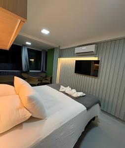 a bedroom with a large bed and a television at Flat Piscina Privativa 90 MT Praia centro in Porto De Galinhas