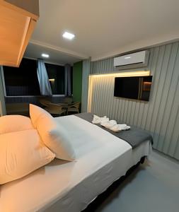 a bedroom with a large bed with two towels on it at Flat Piscina Privativa 90 MT Praia centro in Porto De Galinhas