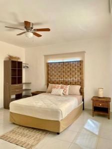 a bedroom with a large bed and a ceiling fan at Cozy Home just 10 minutes from the Pacific! in Todos Santos