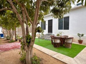 a patio with a table and chairs on grass at Cozy Home just 10 minutes from the Pacific! in Todos Santos