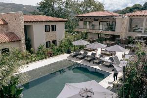 an external view of a villa with a swimming pool and umbrellas at La Gracia Hotel & Spa in San Jerónimo