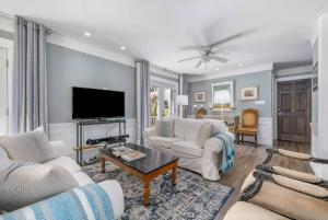 a living room with white furniture and a flat screen tv at Gate House Comfort plus own lake access, dock, 4 mins to beach in West Lake