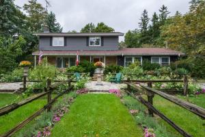 a house with a wooden fence in front of a yard at Gate House Comfort plus own lake access, dock, 4 mins to beach in West Lake
