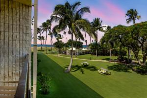 a view of a park with palm trees and benches at Maui Sunset in Kihei
