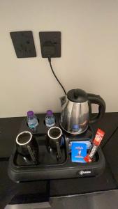 a tea pot sitting on a stove with two cups at Modern studio Self entry in Riyadh