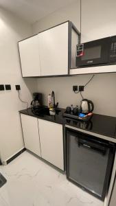 a kitchen with a black counter top and a microwave at Modern studio Self entry in Riyadh