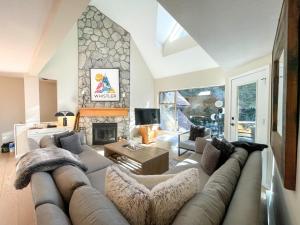 a living room with a couch and a fireplace at Modern Home with Forest Views by Harmony Whistler in Whistler
