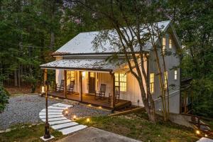 a tiny house with a porch in the woods at NEW White Pine Hideaway Fire pit Hot Tub Games in Ellijay