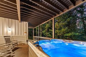 a hot tub in a room with a large window at NEW White Pine Hideaway Fire pit Hot Tub Games in Ellijay