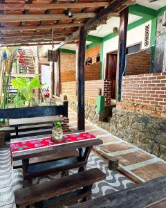 a picnic table and benches on a patio at Cacau Biruta in Itacaré +40 photos