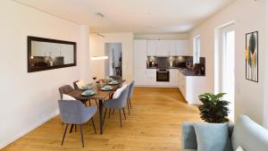 a dining room and kitchen with a table and chairs at RelaxRefugium LUXUS - Küche, Arbeitsplätze, Stellplatz & Komfort für bis 6 Gäste in Königs Wusterhausen +18 photos