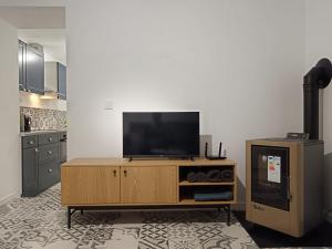 a living room with a television on a wooden entertainment center at Jardin Saint Merry in Fontainebleau