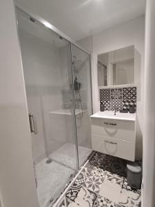 a white bathroom with a shower and a sink at Jardin Saint Merry in Fontainebleau