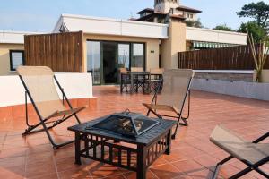 a patio with chairs and a table with a fire pit at Las Terrazas de la Provi, Mejores Vistas in Gijón