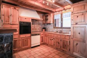 a kitchen with wooden cabinets and a white appliance at Chalet Digitale - Appartement en Chalet 10 personnes MAE-8234 in Montvalezan