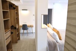 a bedroom with a bed and a desk with a mirror at Las Terrazas de la Provi, Mejores Vistas in Gijón