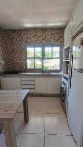 a kitchen with a refrigerator and a table in it at Chame, eu negocio - Centro do Mar Grosso - Laguna in Laguna +19 photos