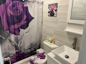 a bathroom with a toilet and a purple shower curtain at Casa Mi Luz - Family-Friendly 3BR Stay with Parking & Self Check-in in San Juan +72 photos