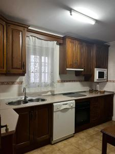 a kitchen with a sink and a microwave at Alojamiento el camarín in Baños de la Encina