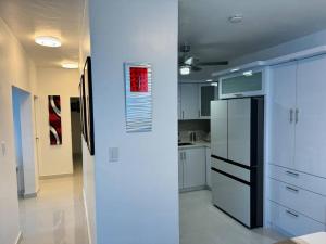 a kitchen with a black refrigerator and white cabinets at Casa Mi Luz - Family-Friendly 3BR Stay with Parking & Self Check-in in San Juan