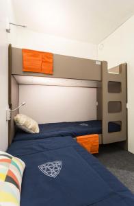 ein Schlafzimmer mit einem Etagenbett mit blauen Laken und orange in der Unterkunft Résidence Varet 2 - Appartement rénové 3 pièces 7 personnes MAE-7854 in Arc 2000