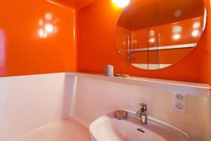 ein orangefarbenes Badezimmer mit einem Waschbecken und einem Spiegel in der Unterkunft Résidence Varet 2 - Appartement rénové 3 pièces 7 personnes MAE-7854 in Arc 2000 + 15 Fotos