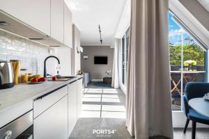 a kitchen with white cabinets and a blue chair at Ferienwohnung Erholen St Peter Ording in Böhl