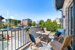 a balcony with a table and chairs and a street at Ferienwohnung Entspannen St Peter Ording in Böhl