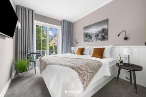 a bedroom with a large white bed and a window at Ferienwohnung Entspannen St Peter Ording in Böhl