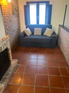 ein blaues Sofa in einem Wohnzimmer mit Kamin in der Unterkunft El rincón del Rosal 15B08 in Tresgrandas