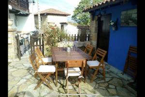 ein Holztisch und Stühle auf einer Terrasse in der Unterkunft El rincón del Rosal 15B08 in Tresgrandas