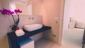 a bathroom with a vase with flowers on a counter at Siracusa Luxury Apartment in Reggio Calabria +43 photos
