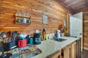a kitchen with wooden walls and a counter with a sink at Fish, Hike and More Ozark Cabin on 300 Acres in Ozark