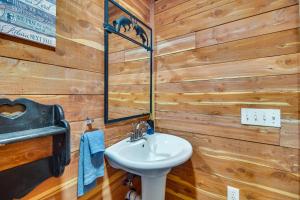 a bathroom with a white sink and wooden walls at Fish, Hike and More Ozark Cabin on 300 Acres in Ozark +16 photos