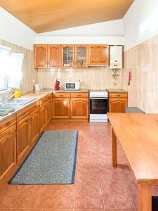 a kitchen with wooden cabinets and a wooden table at Casinha da Serra in Vilar