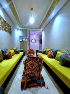 a living room with green couches and a table at Apprt Ennakhil 2 in El Jadida