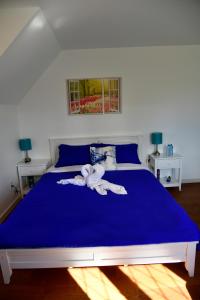 a blue bed with a towel on top of it at The Blue Cottage B&B in Seventy Mile