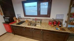 a kitchen counter with a sink and a window at Lares de Yaima in Cholila