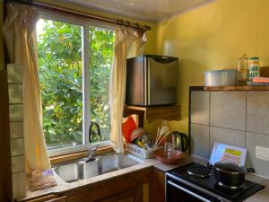 a kitchen with a sink and a window at Fare Tamaruorai in Tubuai