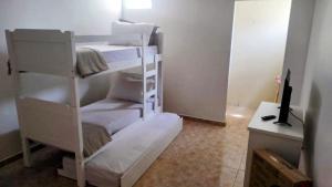 a room with two bunk beds and a desk at Residencial Carvalho AP 1 in Torto