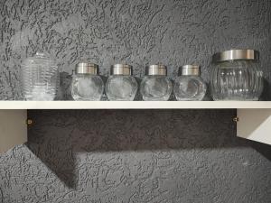 a row of glass jars sitting on a shelf at Residencial Carvalho AP 1 in Torto