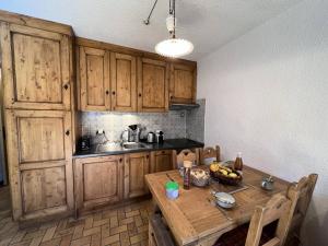 - une cuisine avec une table en bois et un bol de bananes dans l'établissement Résidence Vie De Clare Narcisse - Appartement chaleureux · Centre village · Cheminée MAE-0164, au Monêtier-les-Bains 6 autres photos