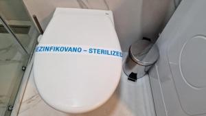 a white toilet in a bathroom with a trash can at LUXURY APARTMAN ELENI ROOMS oaza mira i tišine u centru Vrnjačke banje in Vrnjačka Banja +56 photos