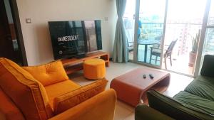 a living room with a couch and a tv at Luxury Skynest with Gym and Pool in Westlands in Nairobi