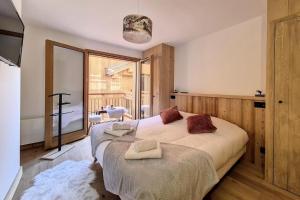 a bedroom with a bed and a large window at Résidence Le Bettex - Chalet Ydilia MAE-9624 in Praranger