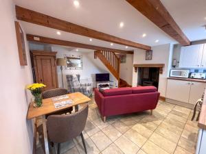 a living room with a red couch and a table at School House Cottage in Buxton