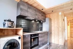 een keuken met een fornuis, een wasmachine en een droger bij Résidence Valmonts A - Appartement duplex rénové · Départ ski aux pieds · Balcon MAE-9904 in Les Bruyères