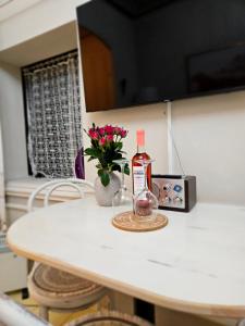 a bottle of alcohol and a vase of flowers on a table at Apartmán Marína in Banská Štiavnica